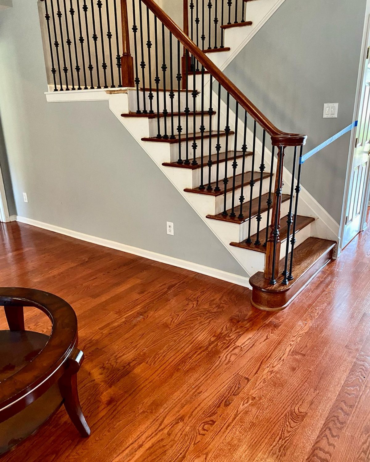 Red oak hardwood flooring with a warm finish in a room next to a staircase.