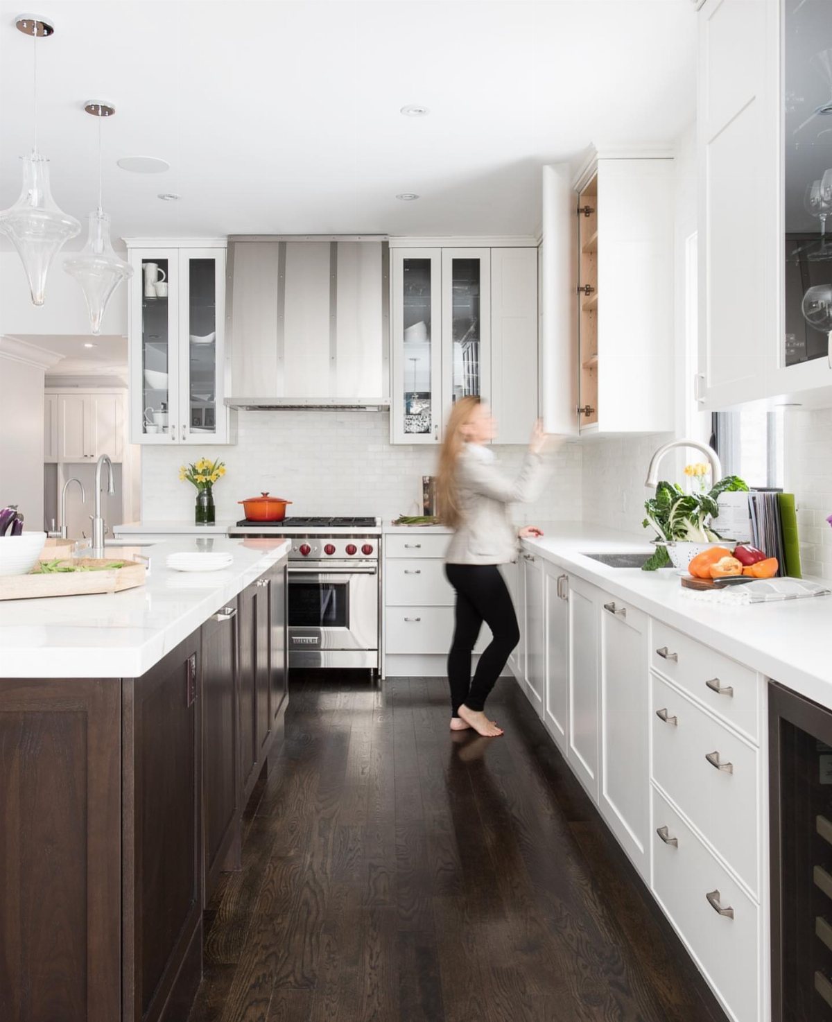 White kitchen cabinets and countertops paired with dark hardwood flooring.