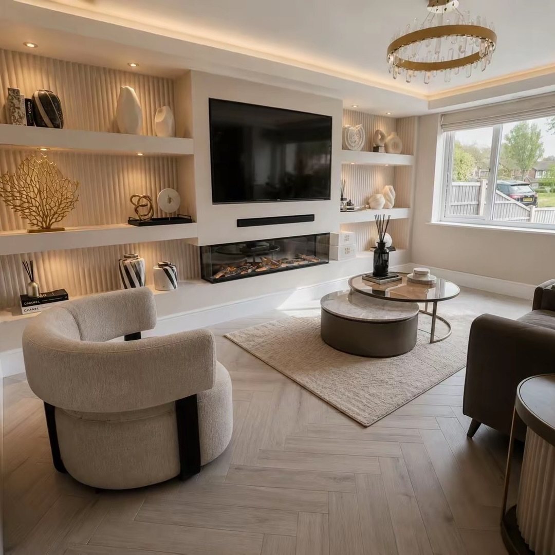 A modern living room featuring a built-in media wall with a television and fireplace.