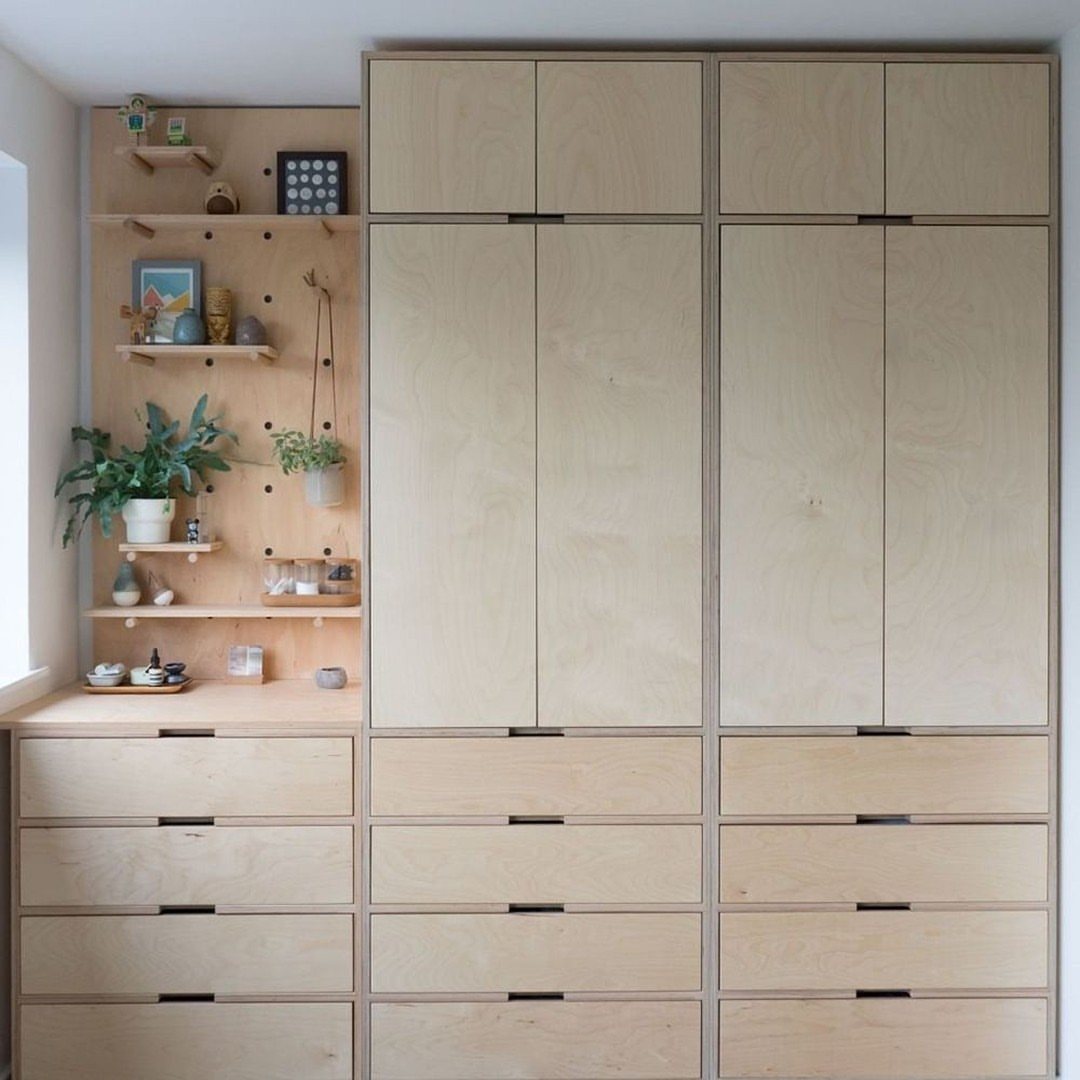 Light plywood cabinetry featuring a pegboard wall with small wooden shelves and decorative items.