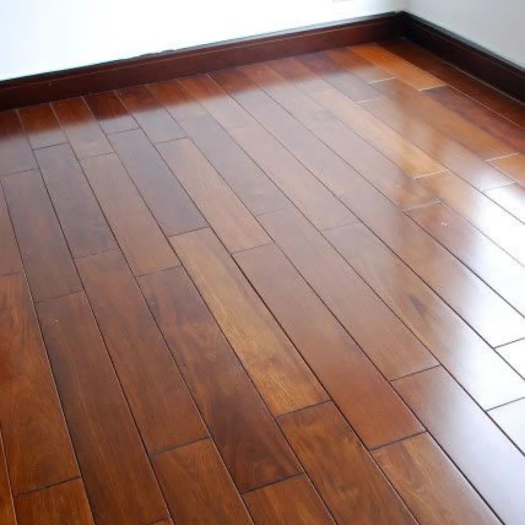 Dark polished wood floor planks of varying lengths installed in a room with white walls.