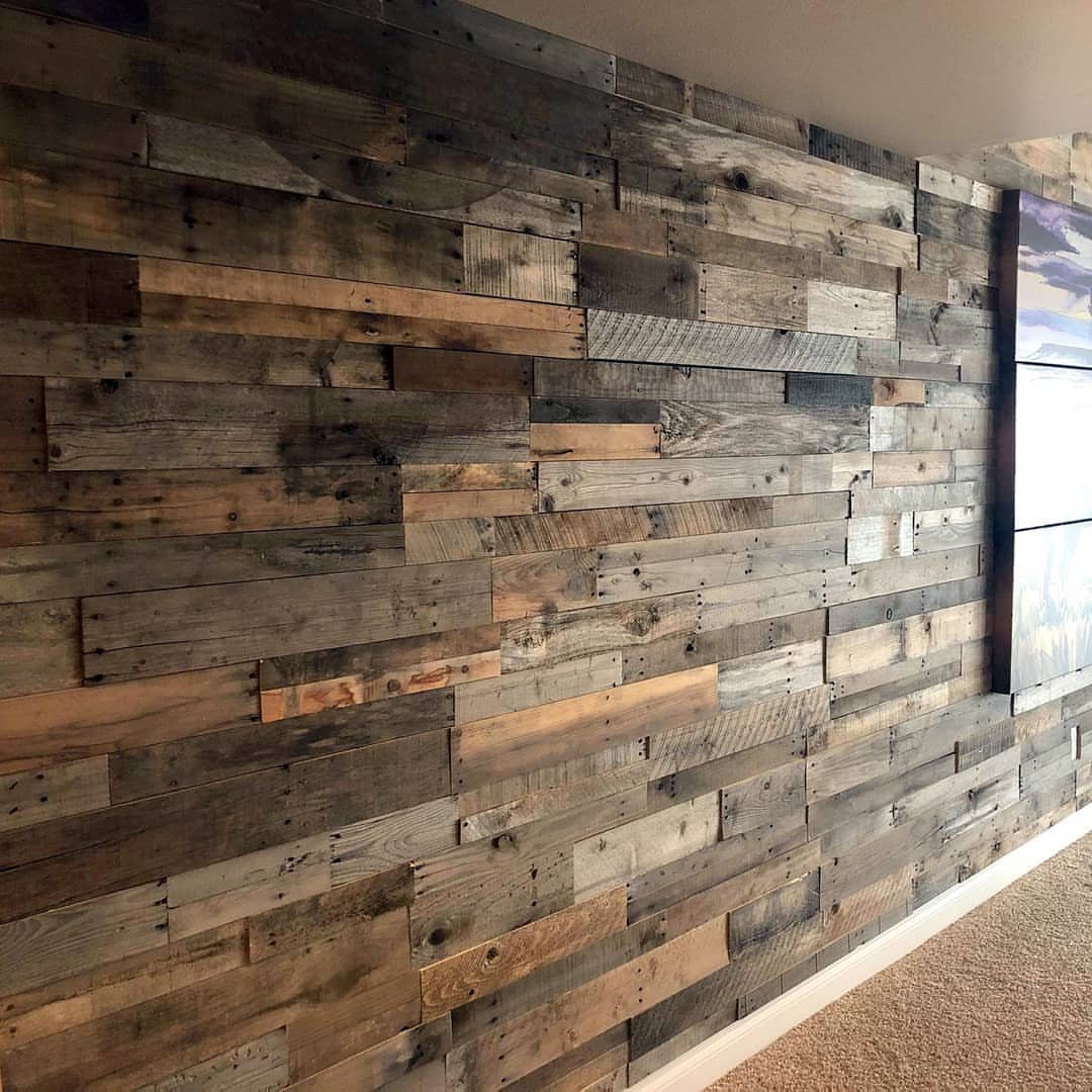 Reclaimed wood planks in various natural tones covering a large interior wall.
